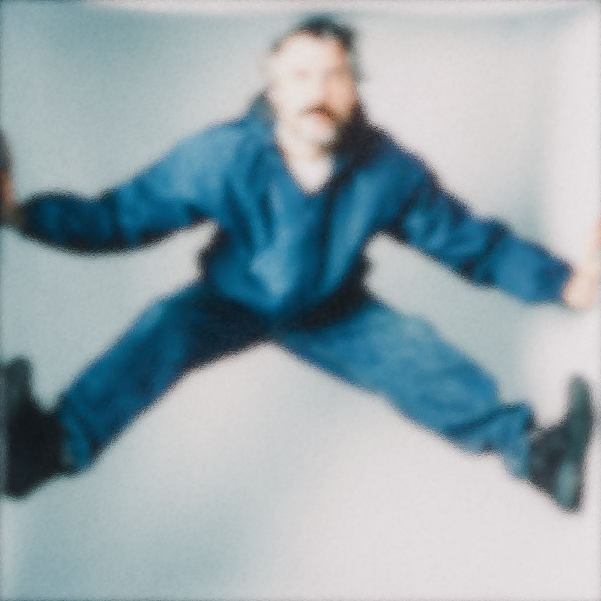 Blurred portrait of man mid-jump in blue clothing